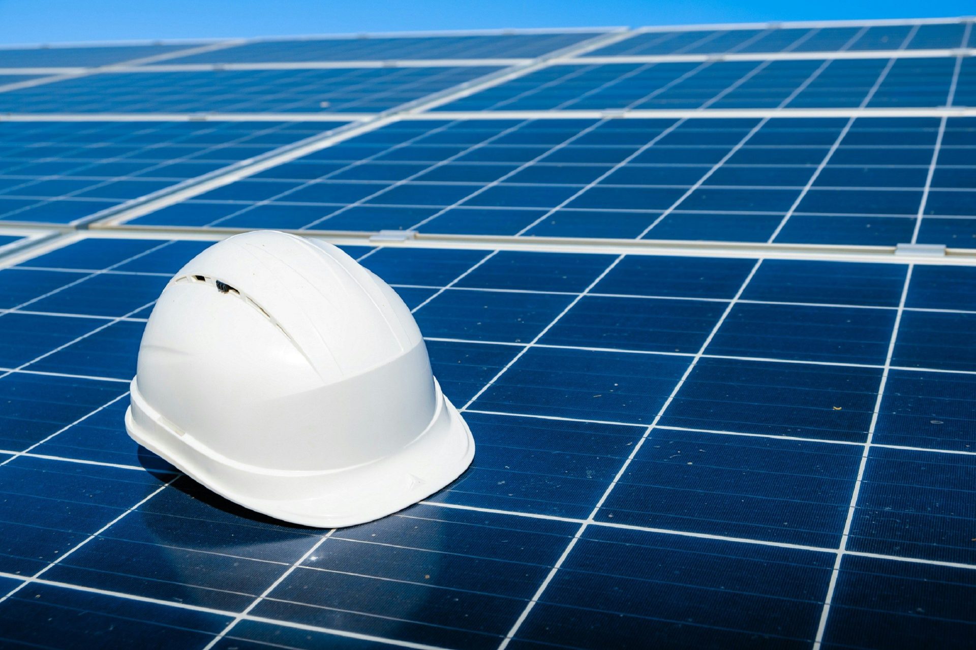 ein weißer Bauhelm, der auf einem Solarmodul liegt