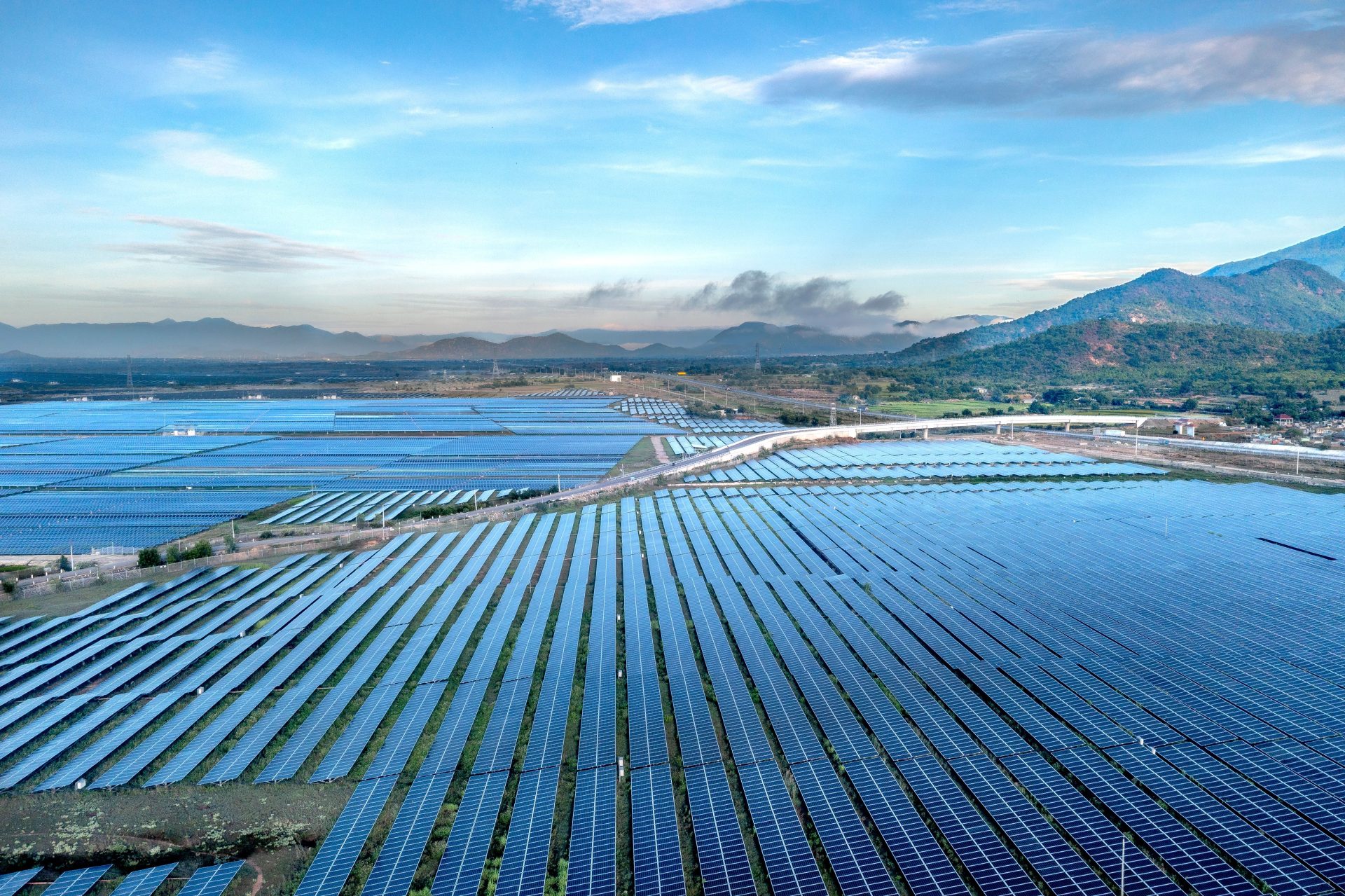Luftaufnahme eines weitläufigen Solarparks unter einem leuchtenden Himmel in der vietnamesischen Provinz Ninh Thuan bei Tageslicht.