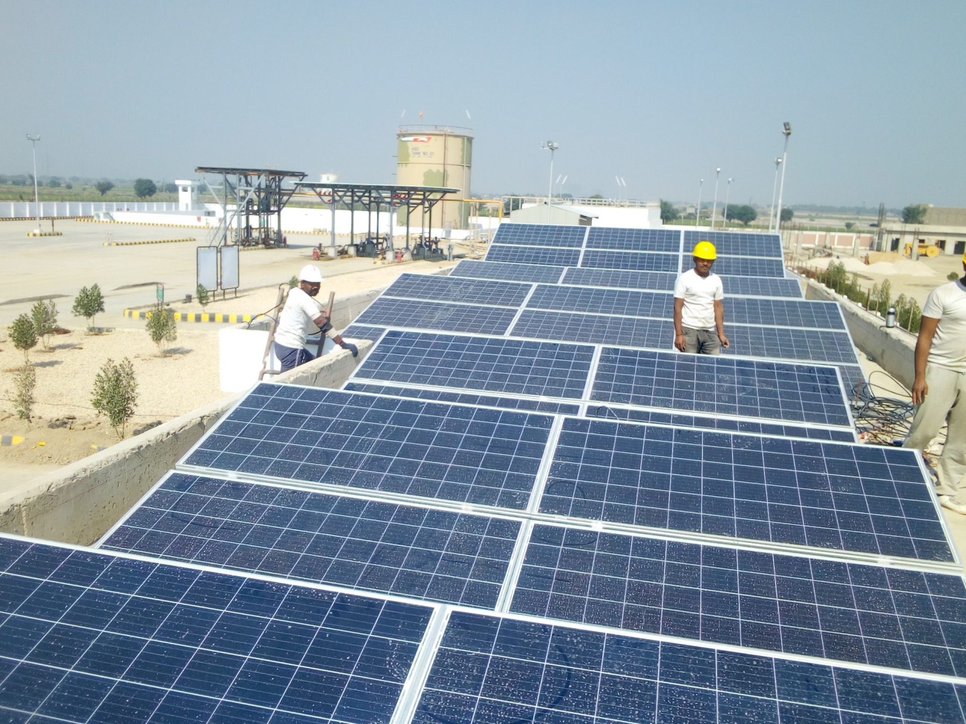 Arbeiter installieren Solarmodule auf einem Dach zur Erzeugung erneuerbarer Energie.